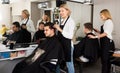 Women hairdressers doing hairstyle for male clientsin in hairdr Royalty Free Stock Photo