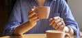 Women hand holding coffee cup over wood table in cafe in sunny day with day light, closeup Royalty Free Stock Photo