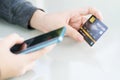 Women hand holding credit card and using cell phone for online shopping Royalty Free Stock Photo