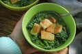 Women hand holding fresh and delicious green soup . Bowl of broccoli with croutons . Diet detox food concept. Top view Royalty Free Stock Photo