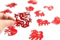 women hand holds Red Chinese zodiac paper cutting Year of the dragon