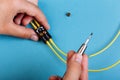 Women Hand holds a screwdriver for tuning the optic attenuator. Selective focus. Blue background