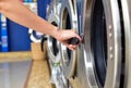 Women hand open washing machine in self service laundry room Royalty Free Stock Photo