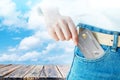 Women hand pick up realistic credit or debit card with old wood table on cloud sky background