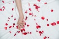 Women hand pulling or grasping white sheets. Hand sign orgasm of woman on white bed sheet with rose petals