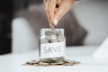 Women hand putting money coin into glass jar for saving money. saving money and financial concept Royalty Free Stock Photo