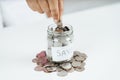 Women hand putting money coin into glass jar for saving money. saving money and financial concept Royalty Free Stock Photo