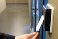 Women hand reaching to use RFID key card to access to office building area and workspace. In building security only for authorized Royalty Free Stock Photo