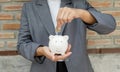 Women hand in suit putting coins into white piggy bank, step up start-up business to success, Saving money for future plan and Royalty Free Stock Photo