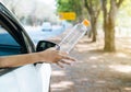 Woman hand throwing plastic bottle trash on the road,Environment and pollution campaign concept Royalty Free Stock Photo