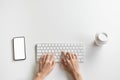 Women hand are typing keyboard and smartphone, coffee cup on the desk. Royalty Free Stock Photo