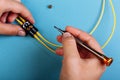 Women Handholds a screwdriver for tuning the optic attenuator. Selective focus. Blue background