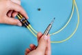 Women Handholds a screwdriver for tuning the optic attenuator. Selective focus. Blue background