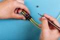 Women Handholds a screwdriver for tuning the optic attenuator. Selective focus. Blue background