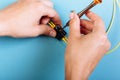 Women Handholds a screwdriver for tuning the optic attenuator. Selective focus. Blue background