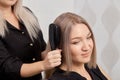 Women hands Barber combs blonde hair with a comb. Beautiful healthy hair.