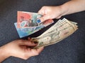 women hands exchanging Australian banknotes and American dollar money Royalty Free Stock Photo