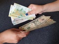 women hands exchanging peruvian banknotes and American dollar money