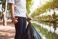 Woman hand holding black color garbage bag,Dispose waste management plastic recycle concept,Close up Royalty Free Stock Photo