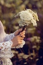Women hands holding flowers in a rural field outdoors, lust for life