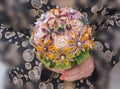 Women hands holding a handmade bouquet of artificial flowers