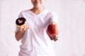 Woman hands holding red apple and baked chocolate donut on white background,Healthy diet,Dieting concept Royalty Free Stock Photo