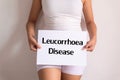 Woman hands holding a white sign with the word leucorrhoea disease on white background Royalty Free Stock Photo