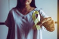 Woman hand holding yellow ribbon on color background,Suicide prevention,Cancer disease awareness concept Royalty Free Stock Photo