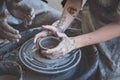 Women hands. Potter at work. Creating dishes. Potter`s wheel. Dirty hands in the clay and the potter`s wheel with the