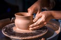Women hands. Potter at work. Creating dishes. Potter& x27;s wheel. Dirty hands in the clay and the potter& x27;s wheel Royalty Free Stock Photo
