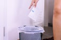 Woman hands putting white sanitary napkin in to plastic bag or trash,Close up