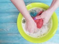 Women hands are washed holding home foam service in a basin on a blue on a wooden background Royalty Free Stock Photo