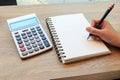 Women hands writing with pencil, notebook and Calculator