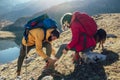 Woman has sprained her ankle while hiking, her friend uses the first aid kit to tend to the injury