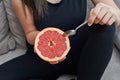 Women have spoon and eat grapefruit