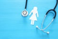 women healf Insurance . concept image of Stethoscope and female figure on wooden table. top view.