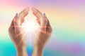 Healing hands with bright sunburst on rainbow background Royalty Free Stock Photo