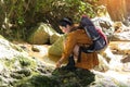 Women hiker with backpack checks map to find directions in wilderness area at waterfalls and forest. Royalty Free Stock Photo