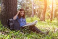 Women hiker with backpack checks map to find directions in wilderness area Royalty Free Stock Photo