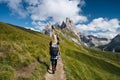 Women hiker on trail path and epic landscape of Seceda peak in Dolomites Alps, Odle mountain range, South Tyrol, Italy