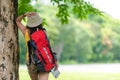 Women hiker or traveler with backpack adventure holding map to find directions and walking relax