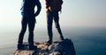 Women hikers looking at the view on seaside mountain top rock edge Royalty Free Stock Photo