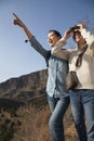 Women hiking, using binoculars, pointing at the mountain top Royalty Free Stock Photo