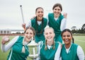 Women, hockey team and winning trophy in portrait, celebration and success in competition on field. Champion girl group