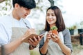 Women hold cactus and a man writing note in a book. Love couple enjoy hobby with darden cactus Royalty Free Stock Photo