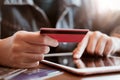 Women hold card and use tablet on wood table,Online shopping,hands holding credit card and using laptop Royalty Free Stock Photo