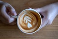 women Holding coffee cup, wooden table cafe while having coffe Royalty Free Stock Photo