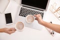 Women holding coffee cups at modern workplace in office