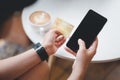 Women are holding credit card and using mobile phone to pay for online shopping in a coffee shop. Royalty Free Stock Photo