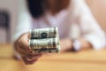 Women holding and give dollar money in the office. The concept of spending by cash.